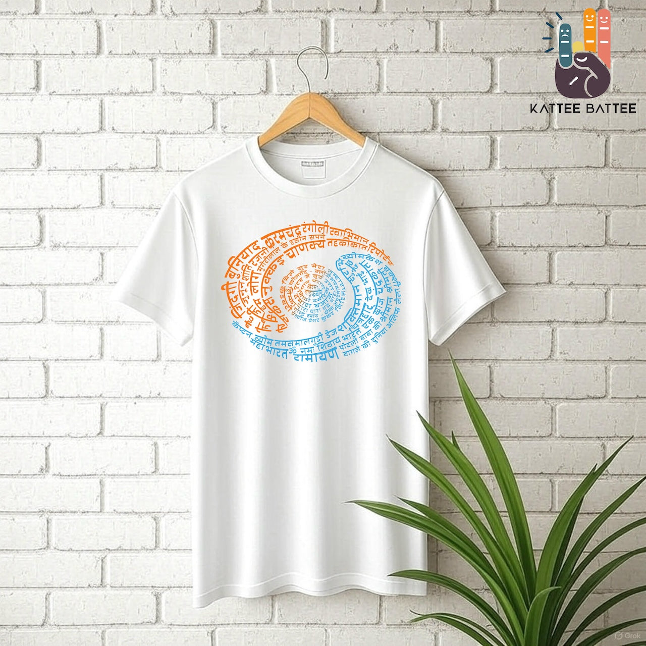 A white short-sleeve t-shirt hanging on a wooden hanger against a white brick wall, featuring a circular spiral graphic made of orange and blue Devanagari text that depicts Doordarshan Nostalgia. A green plant is visible in the bottom right corner, and the 'KATTEE BATTEE' brand logo is in the top right.